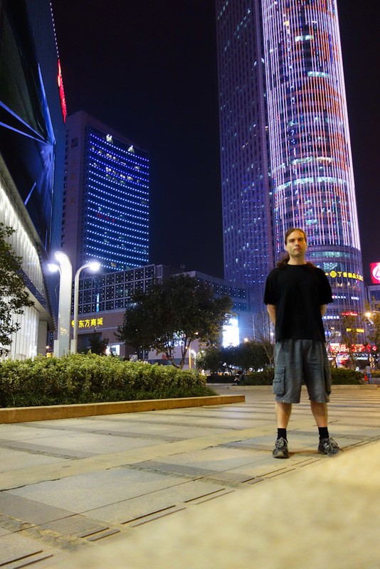 Back to China - Shanghai - Nanjing - Hangzhou - 2012 - Its me, with a cool building and my extra large shorts. I have been wearing the same clothes for 3 days straight now. In fact ever since arriving in N
