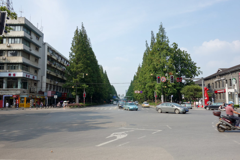 Back to China - Shanghai - Nanjing - Hangzhou - 2012 - Example of wide tree lined streets. Both Starbucks and Costa coffee on the right in the restored old buildings. Are they owned by the same company in 