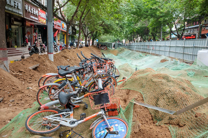 The great loop of China - April 2018 - Now I headed north along a tree lined street, where a new pipe was being installed. A great place to park your share bike.