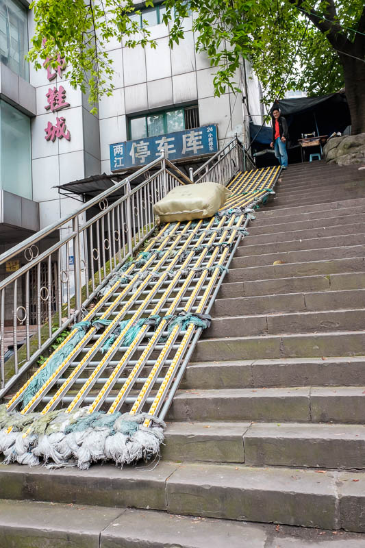 The great loop of China - April 2018 - You have to climb lots of steep staircases in Chongqing. The bamboo pole guys send packages of anything you can imagine down the stairs by stuffing th