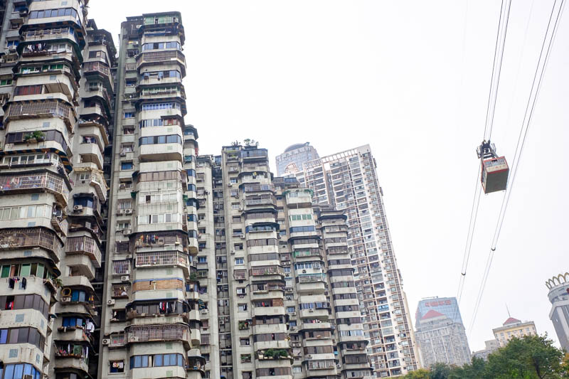 China-Chongqing-Yangtze-Chaotianmen - Vertigo inducing shot of the cable car passing some low rent apartments.