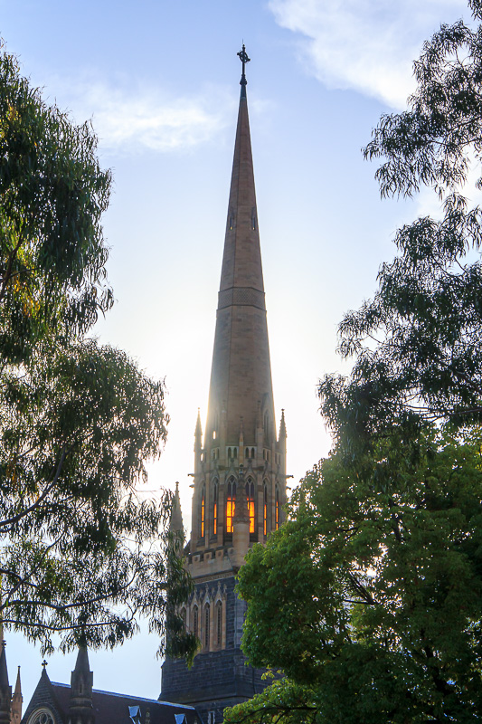  - Turned the corner and walking back into the sun now. The sun is shining through the orange windows of the church spire.