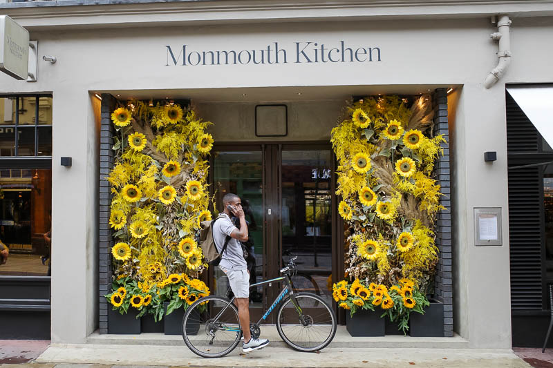 England-London-Chinatown - Many pubs and shops in London are decorated with similar fake floral displays. This guy is phoning the royal sunflower appreciation association to rep