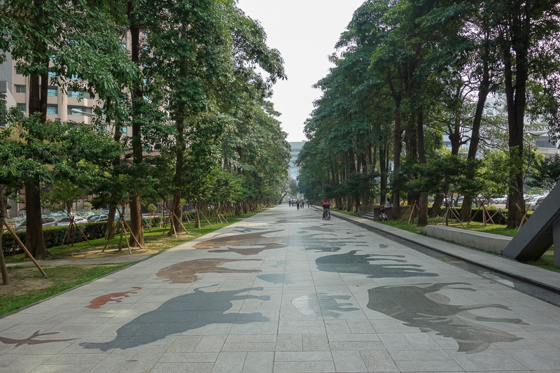 Taiwan-Taichung-Museum-Xitun - This is the walkway to the natural science museum. It has marble dinosaur inlays. There really arent many trees in Taichung! This few hundred metres o