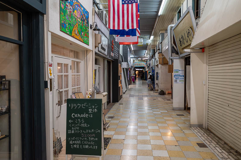 Japan-Fukui-Station - I found a little small arcade area behind the cinema that I had not seen before. The shop with the flags is secondhand clothes. There are a lot of sec