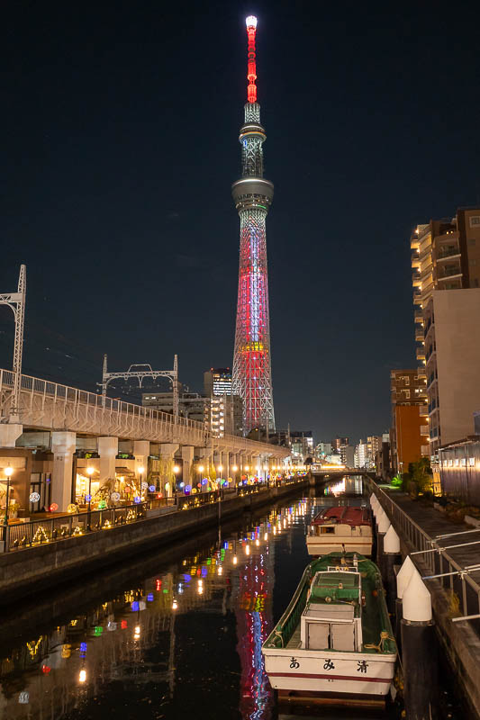 Japan-Tokyo-Skytree - Second view of skytree. Portrait orientation. A canal, a train overpass, and restaurants under it.