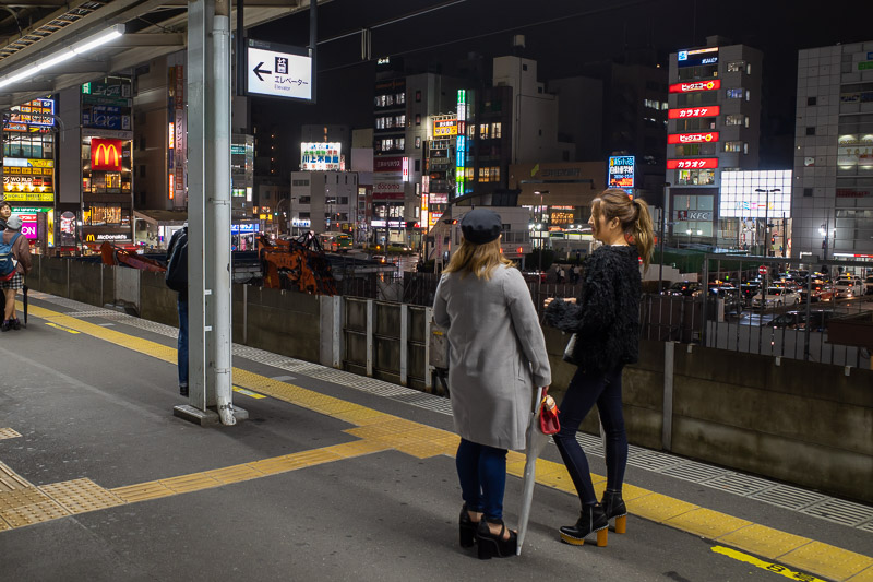 Japan-Tokyo-Shin Koiwa-Pasta - I like it when train platforms have a view. Not of the girls, of the shops behind it. Although thats some impressive shoes they are wearing to look sl