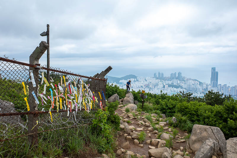 Korea-Busan-Hiking-Jangsan - With the amount of ribbons here, I guess the old summit has been off limits for a while, and this is the new summit spot. A Korean man nearby is tryin