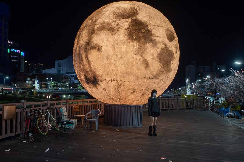 Korea-Daejeon-Jungangro - Girl posing with fake moon and rubbish.
