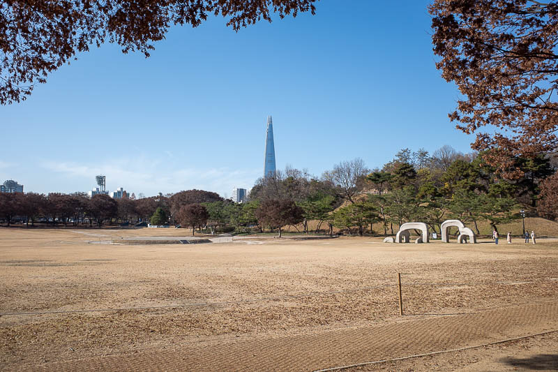 Korea-Seoul-Olympics - A family of stone elephants frolicking in the sun with the Lotte tower in the background.