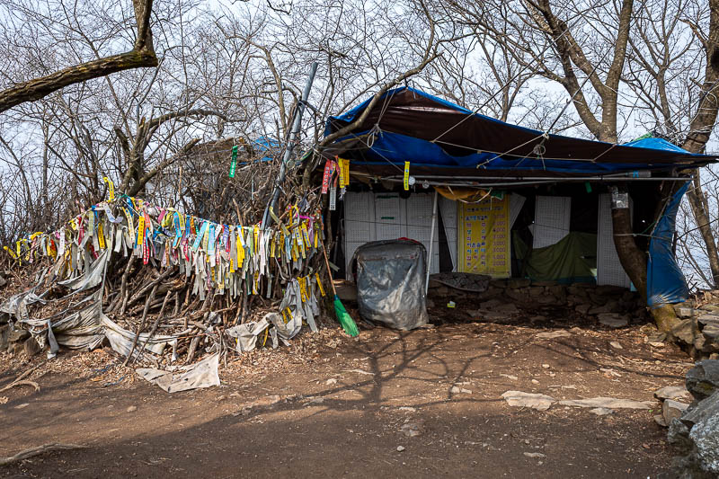 Korea-Seoul-Hiking-Yebongsan - The summit area, and all the hiking club flags. I think on weekends an old wizard sells ice creams inside the tent, possibly transported to the top by
