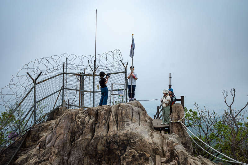 Korea-Seoul-Hiking-Gwanaksan - Behold, the summit, with a Korean flag and barbed wire.
