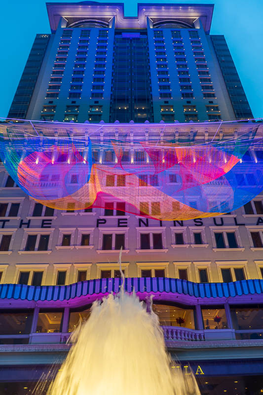 Hong Kong-Tsim Sha Tsui - The Peninsula Hotel. It has a fountain and a neon anti suicide net.