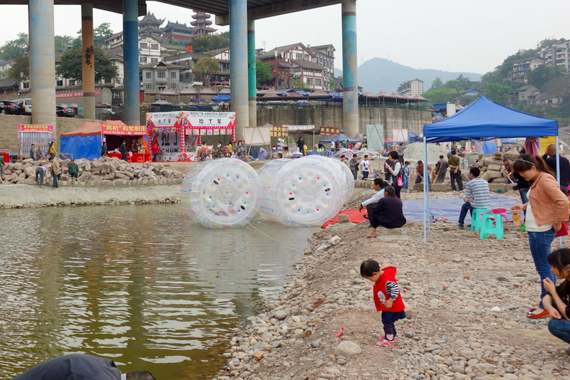China-Chongqing-Ciqikou-Temple - Alternatively, someone has pumped some filthy water into a temporary pond to put kids inside air tight plastic cocoons and then ? They didnt seem to g