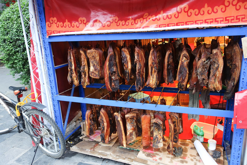 Sichuan - China - Chengdu - Chongqing - March 2013 - Dried meat hanging in an old street. Huge slabs of it. Pork or beef, I am not sure, color makes it look beefy, but the amount of fat suggests pork. I 